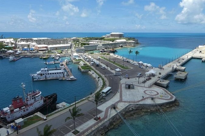 A cruise dock, a marina and old stone buildings seen from the air